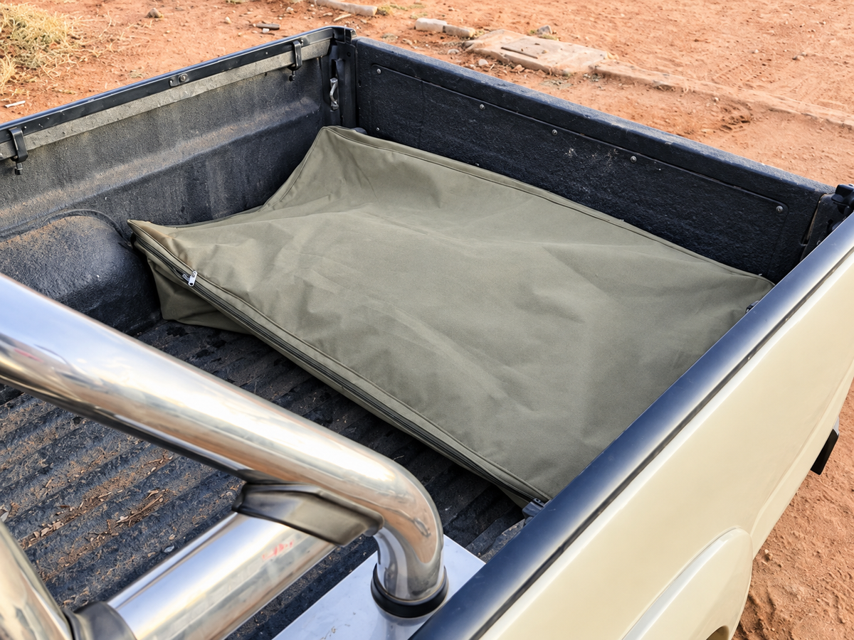 Olive-grey Bakkie Bag zipped closed in a bakkie load bed